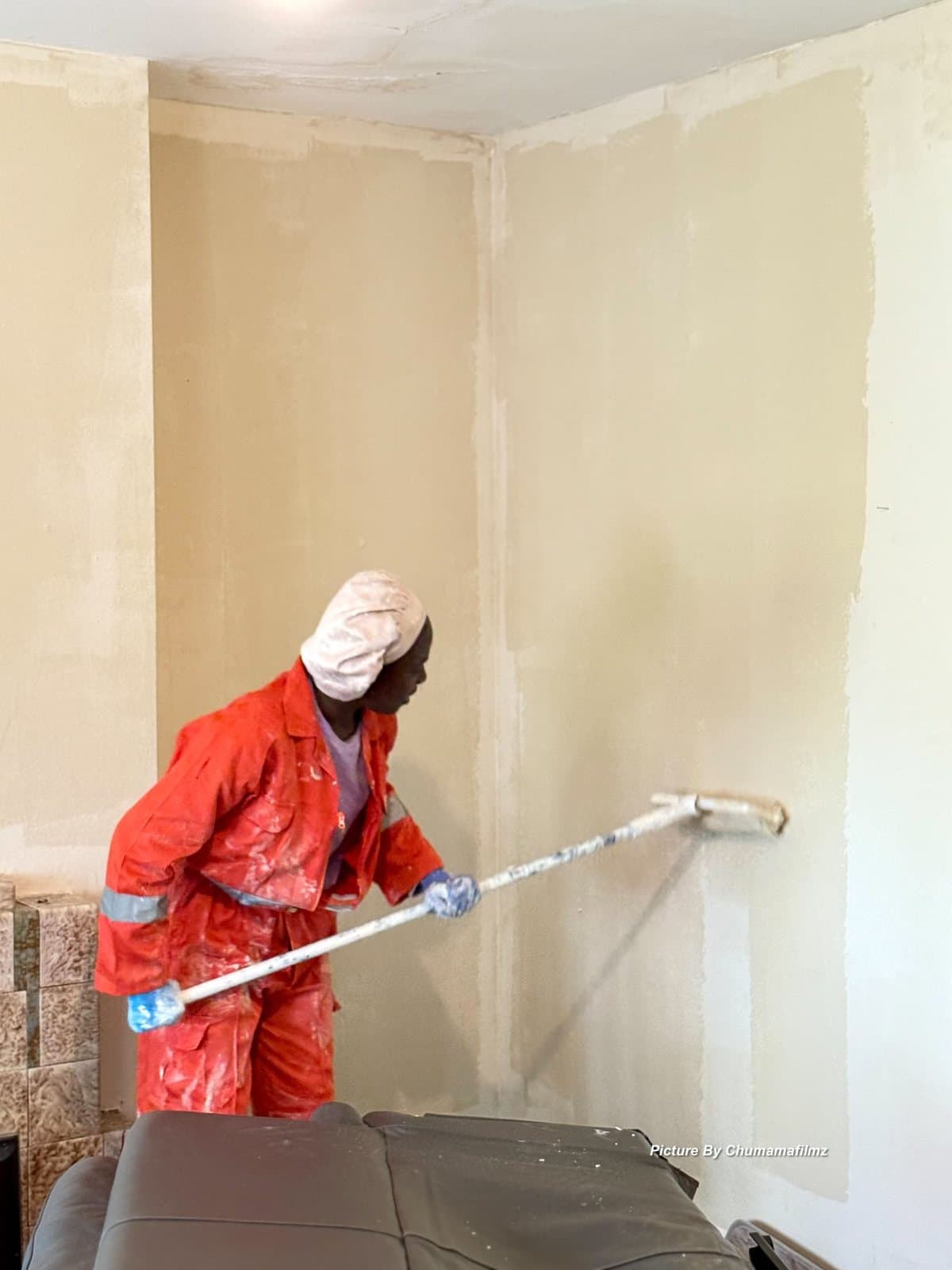 Peeman operative rolling coating onto a freshly plastered wall